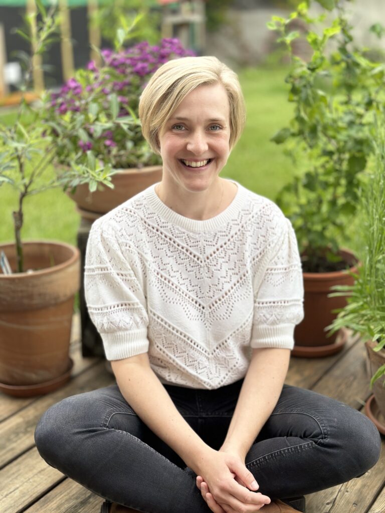 Hebamme Jana Girke im garten sitzend